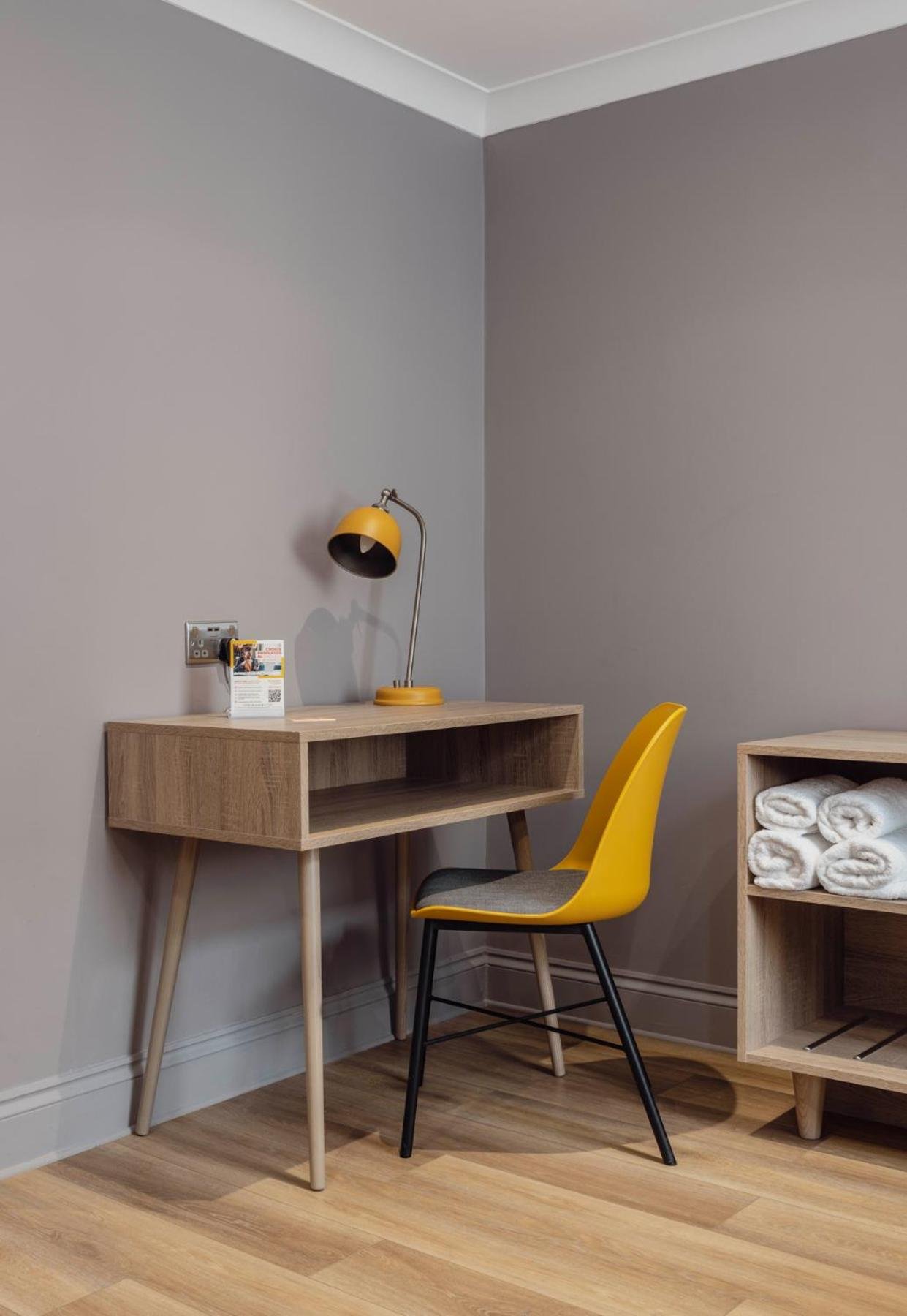 a desk and a yellow chair next to a wall at Comfort Inn Victoria in London