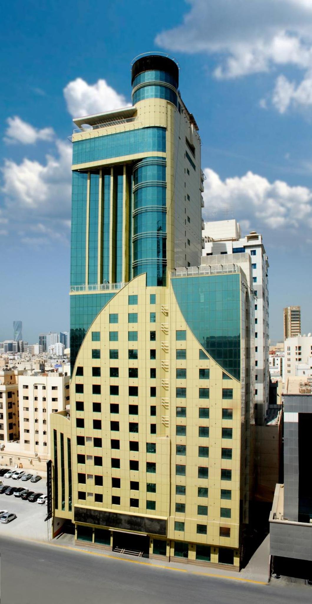 a tall building with glass windows in a city at Frsan Palace Hotel in Manama