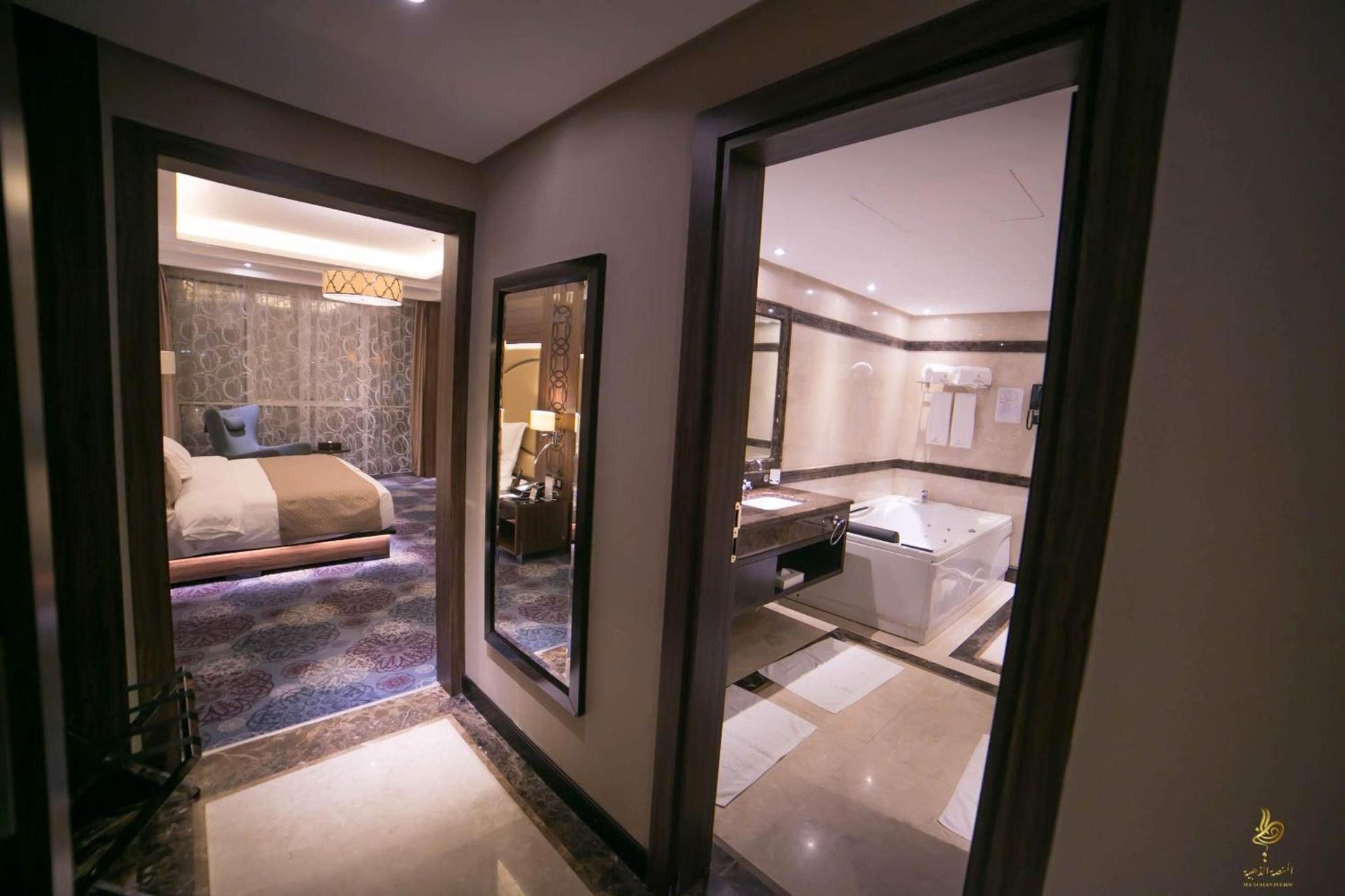 a bathroom with a bedroom with a bed and a mirror at Casablanca Grand Hotel in Jeddah