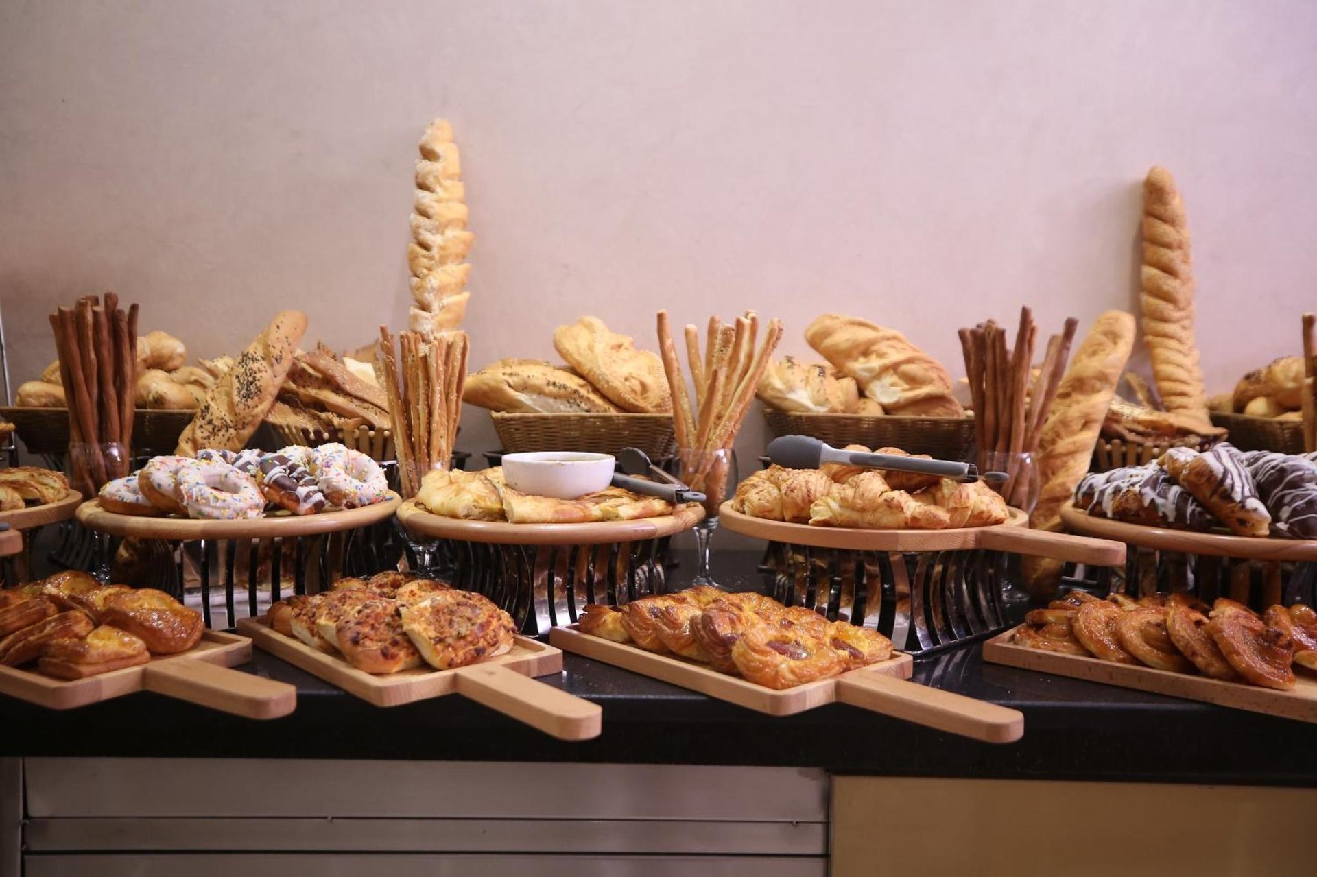 a buffet of different types of bread and pastries at Cairo Taj Hotels & Suites - Dokki in Cairo