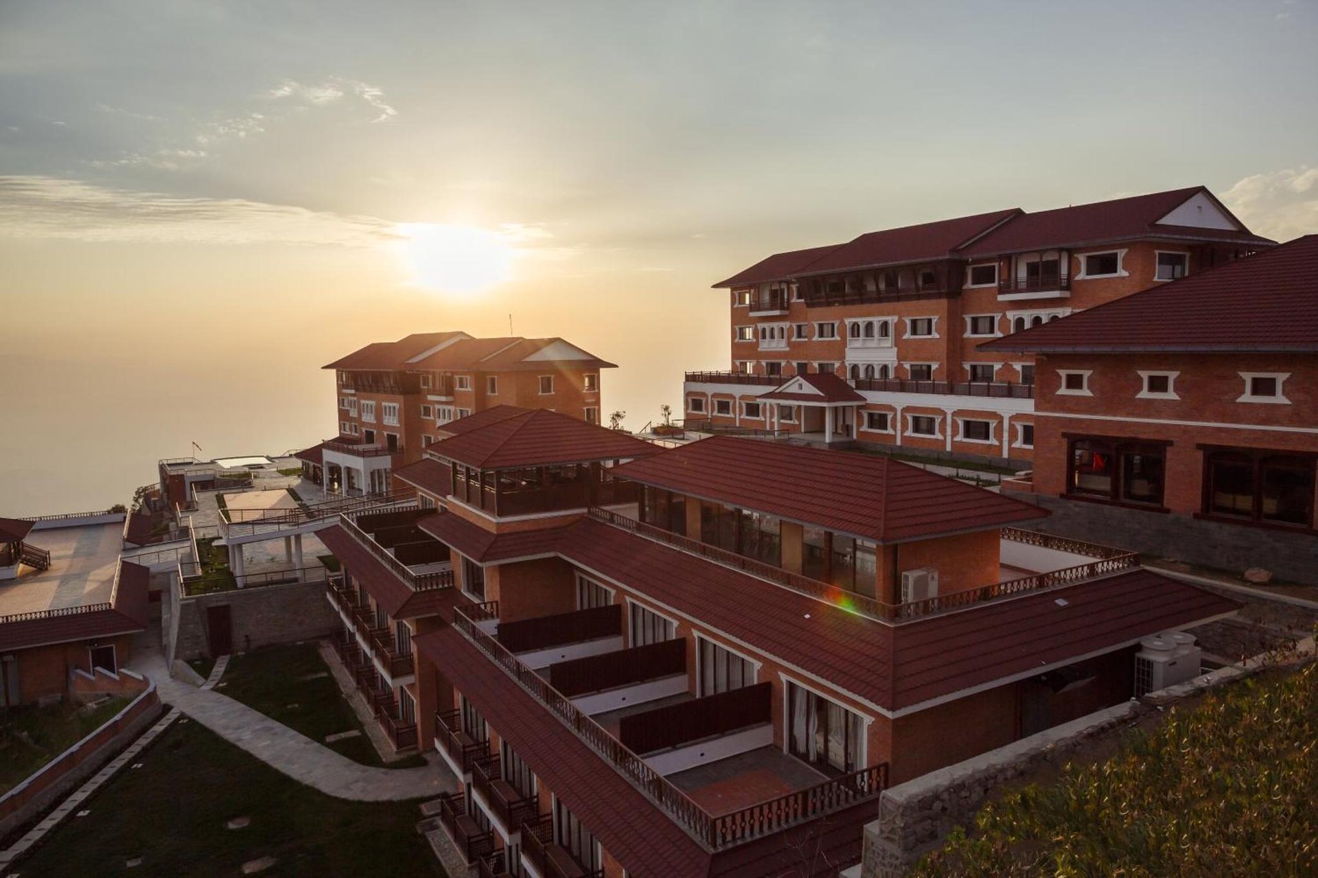a group of buildings with the sunset in the background at Chandragiri Hills Resort Kathmandu-Luxury in the Clouds in Thānkot