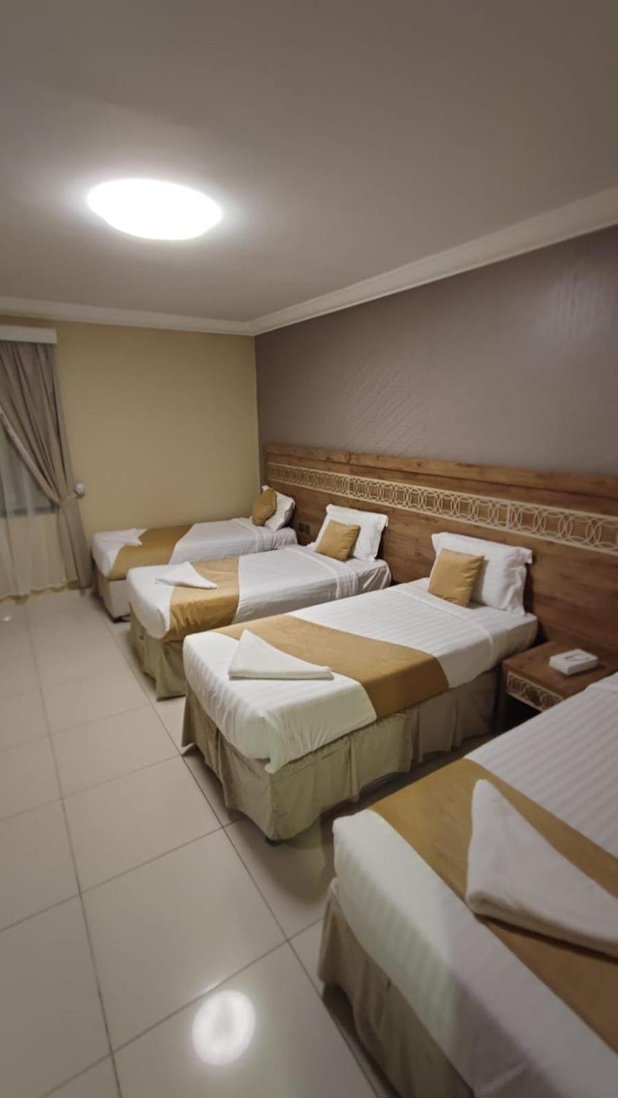 a group of four beds in a room at Razana Al-Hafaer in Makkah +2 photos
