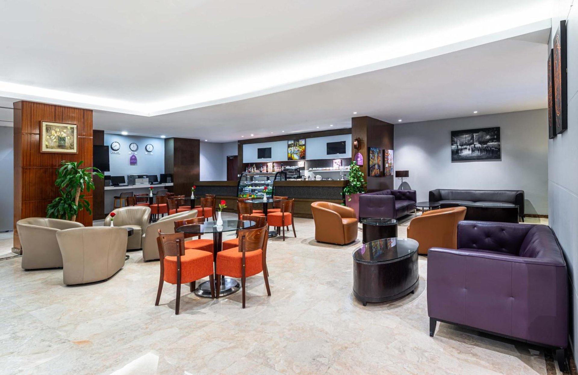 a lobby of a hotel with tables and chairs at Razana Hotel Al Jubail in Al Jubayl