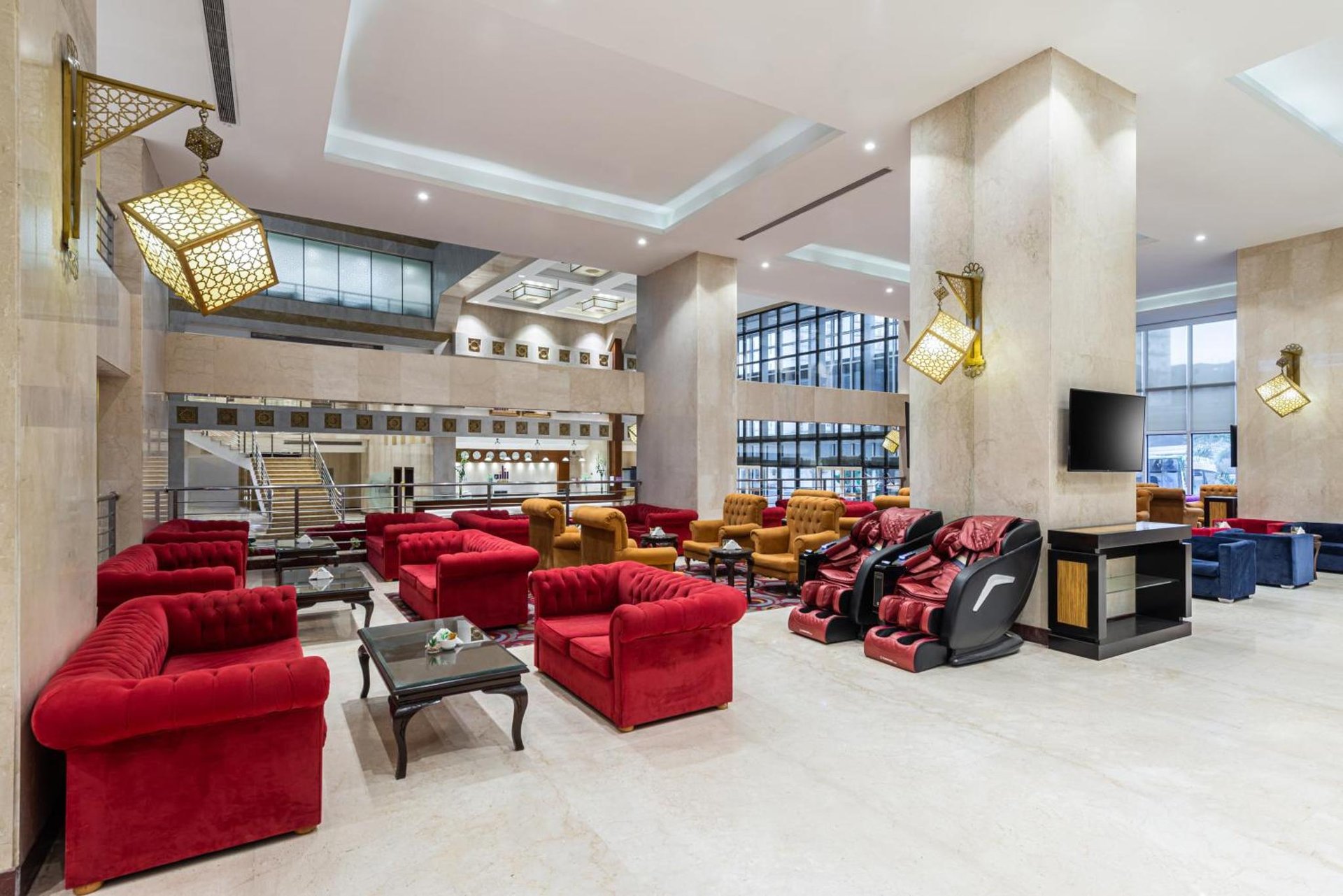a lobby with red couches and chairs at Razana Al Rawdha Hotel in Mecca