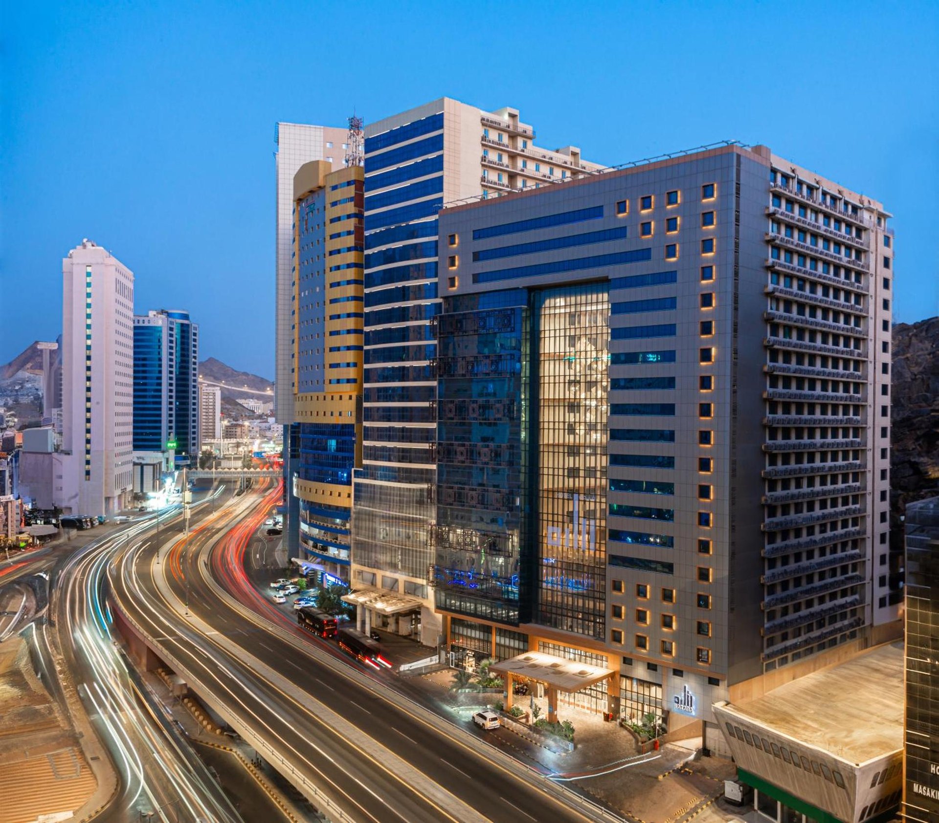 a city skyline with tall buildings and a highway at Razana Al Rawdha Hotel in Mecca