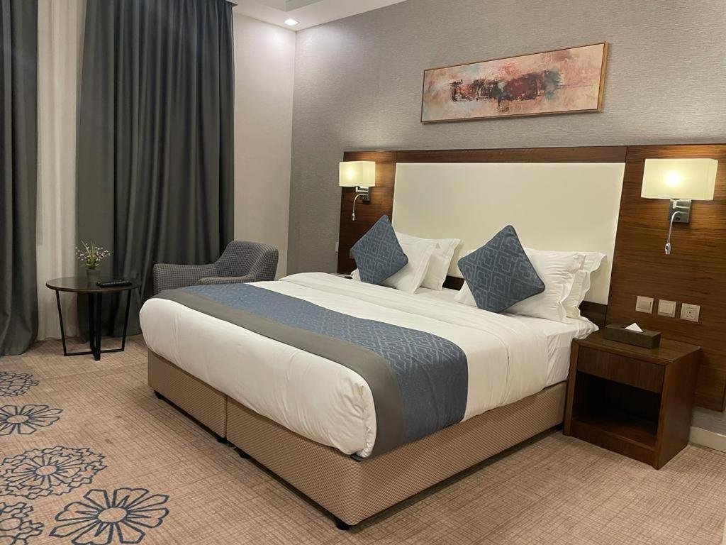 a bedroom with a large bed in a hotel room at فندق فربيون المجاردة - Ferbion Hotel Almajardah in Al Majaridah