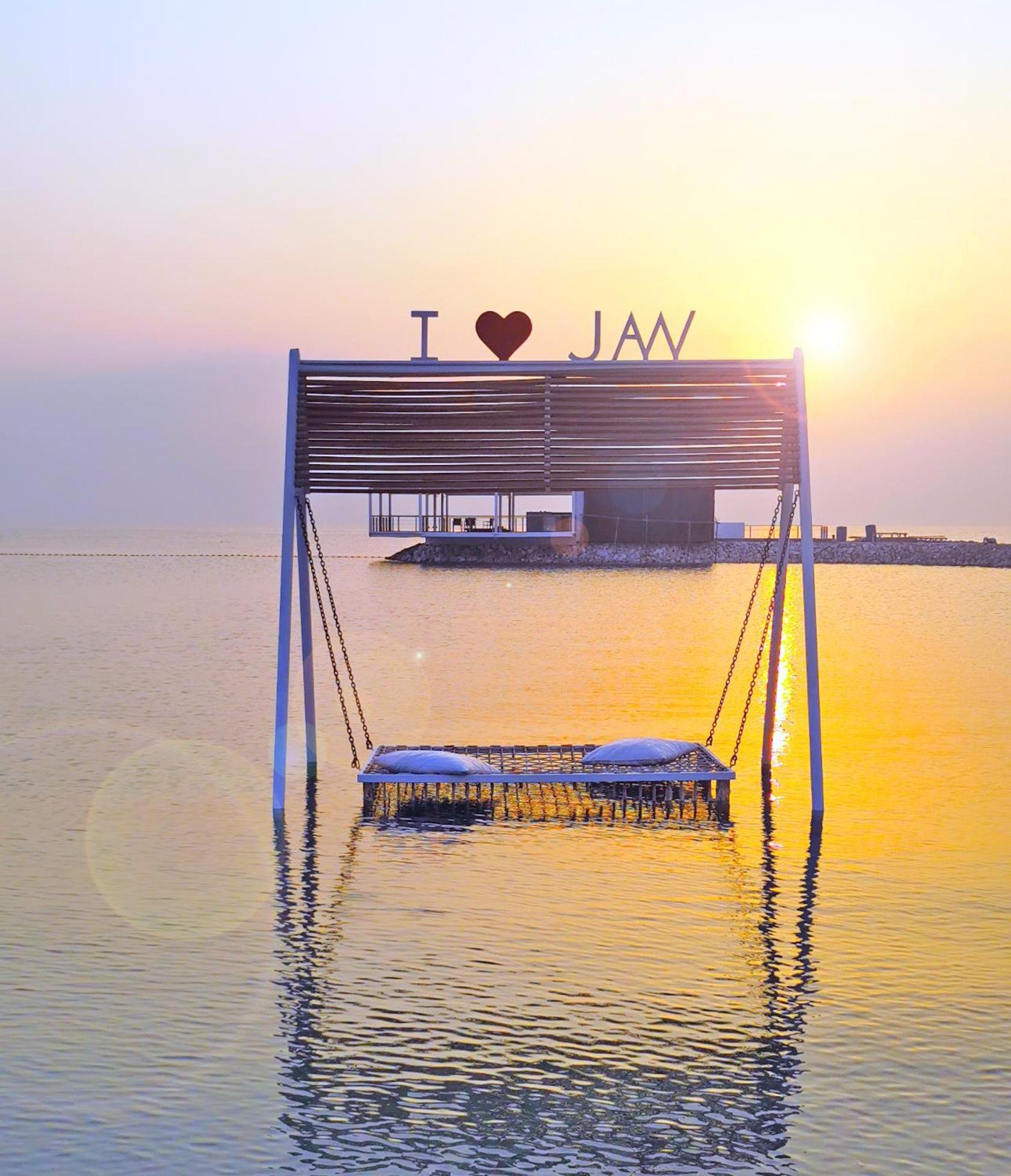 a dock in the water with a heart sign on it at Jaw Resort & Spa in Manama