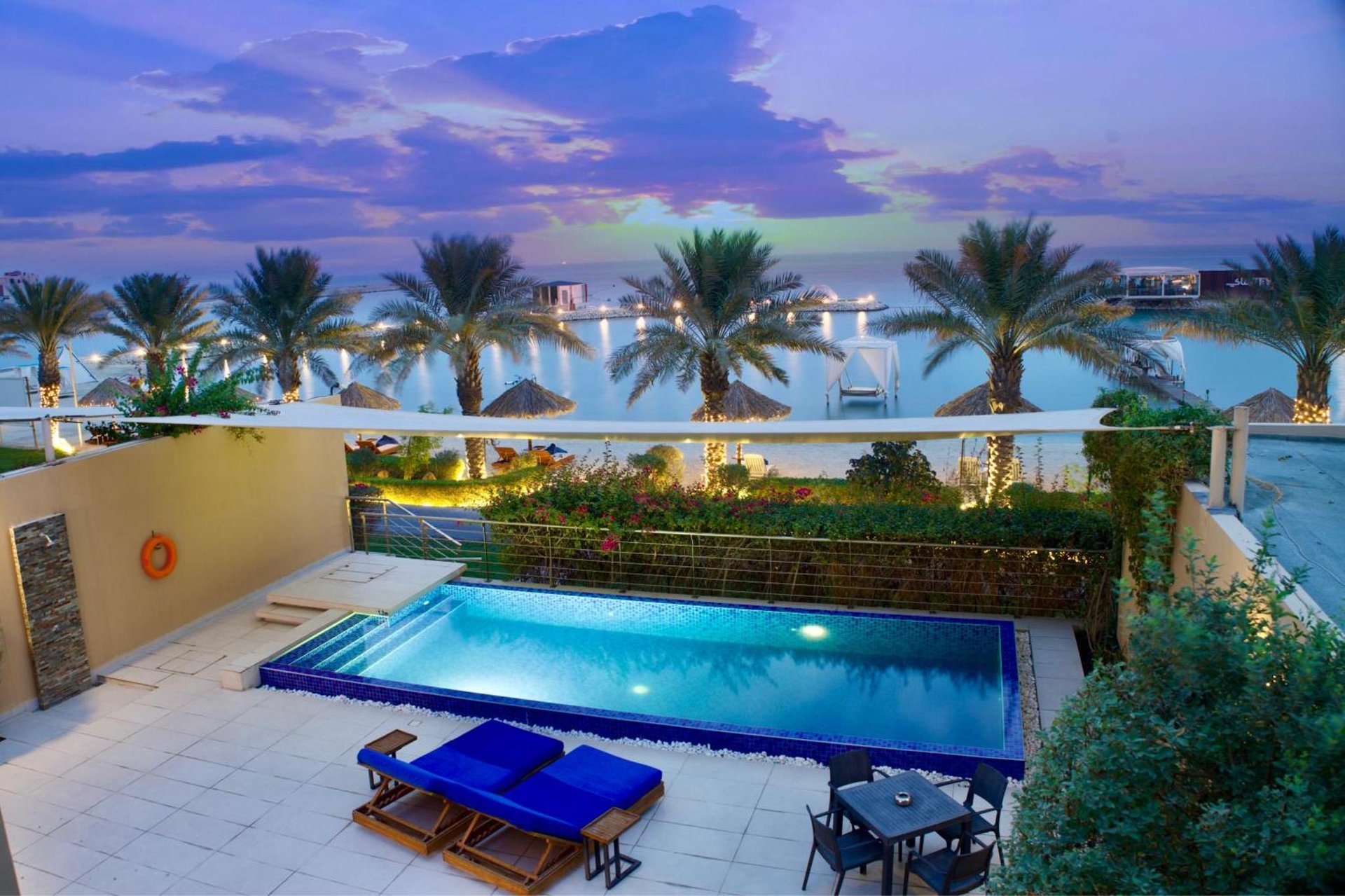 a swimming pool on top of a building with palm trees at Jaw Resort & Spa in Manama