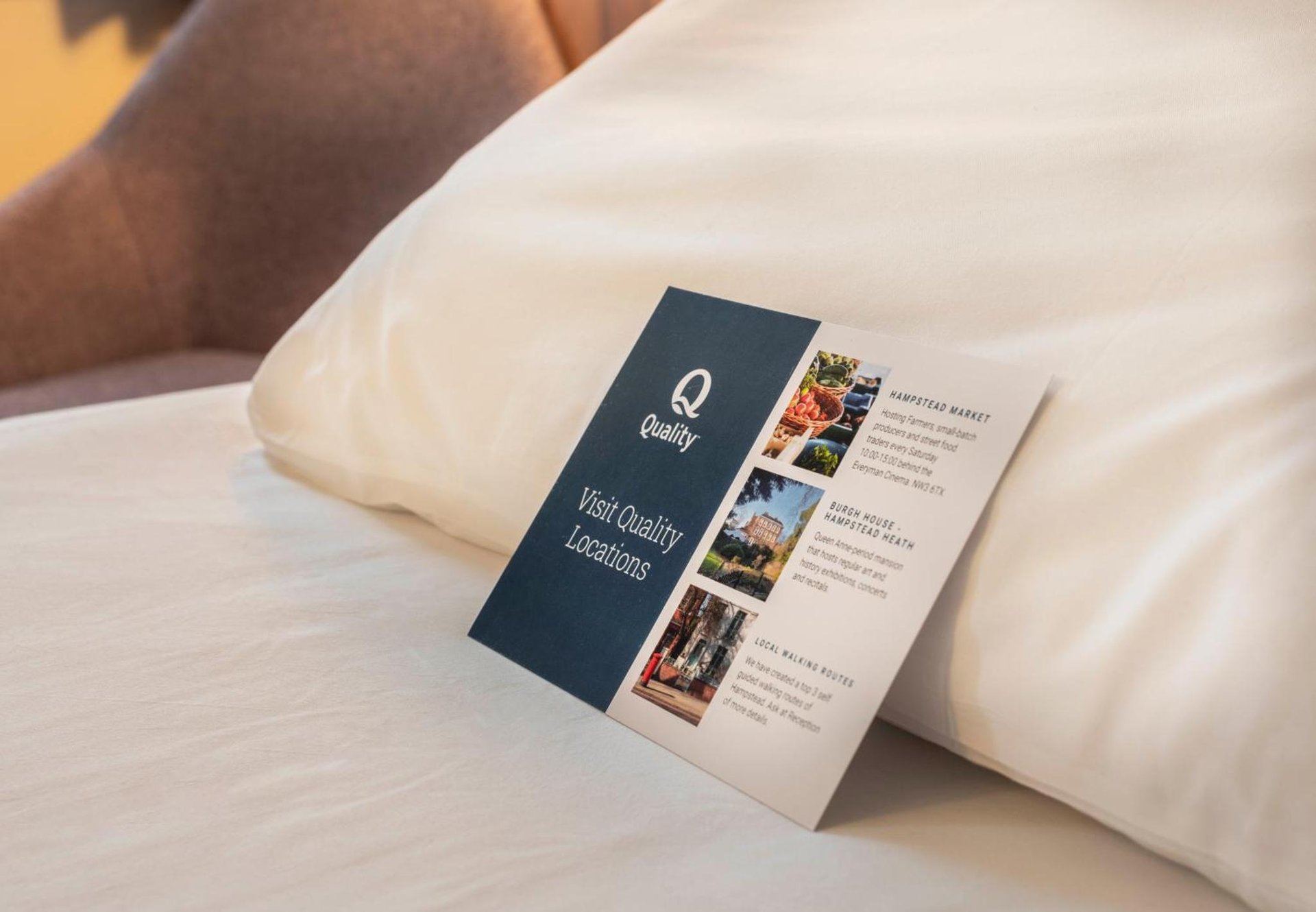 a brochure on the side of a bed at Quality Hotel Hampstead in London