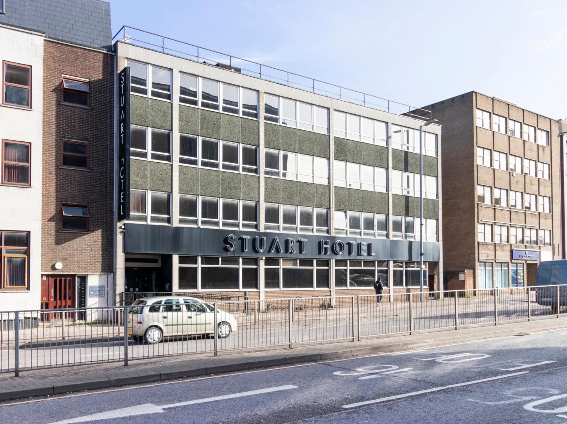 a white car parked in front of a building at Stuart Hotel in Luton