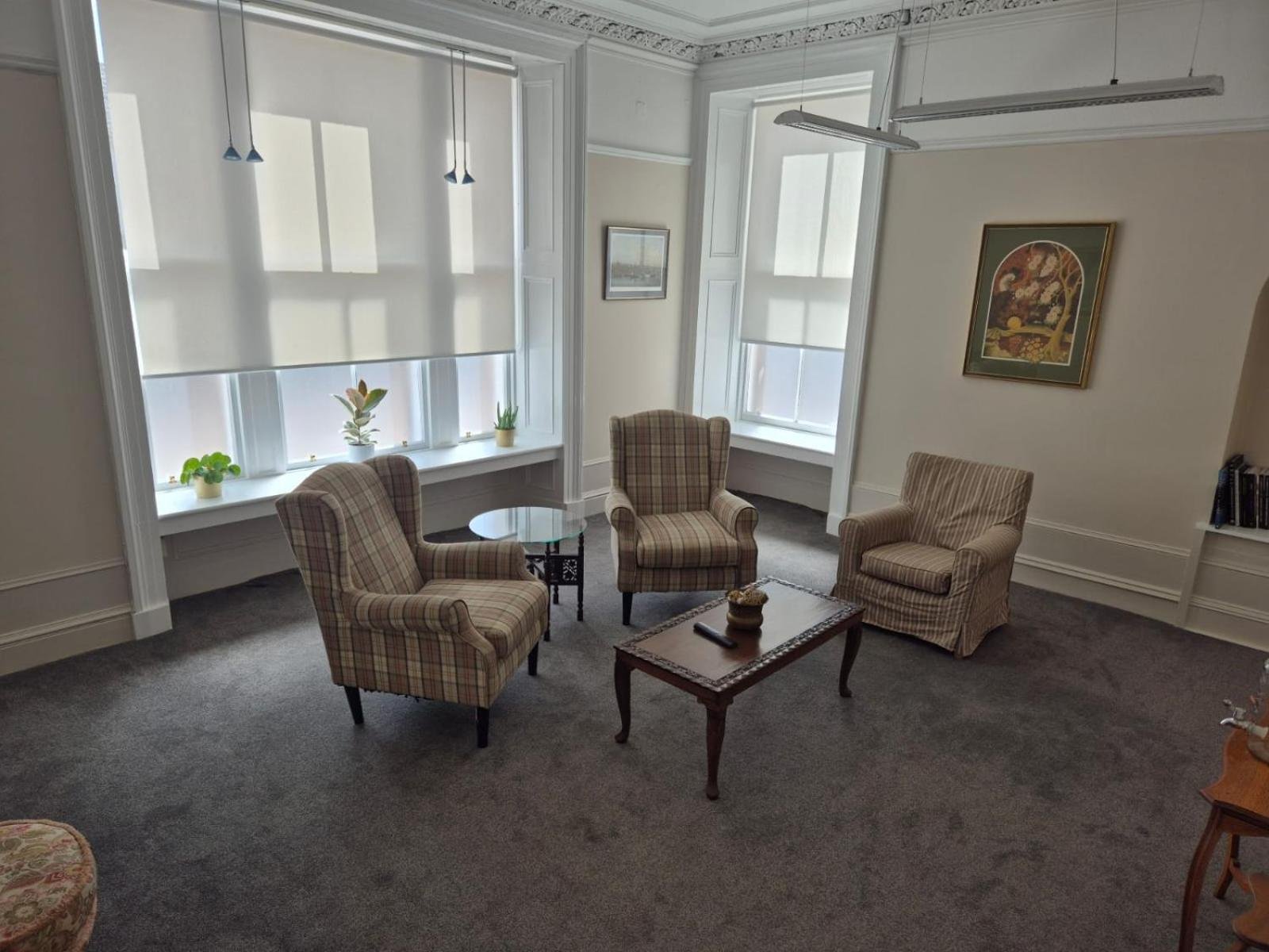 a living room with chairs and a table and windows at Bank House in Inverness