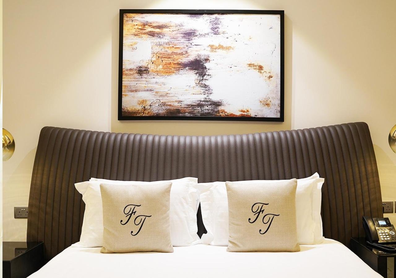 a bed with white pillows and a painting above it at Farhan Tower in Juffair