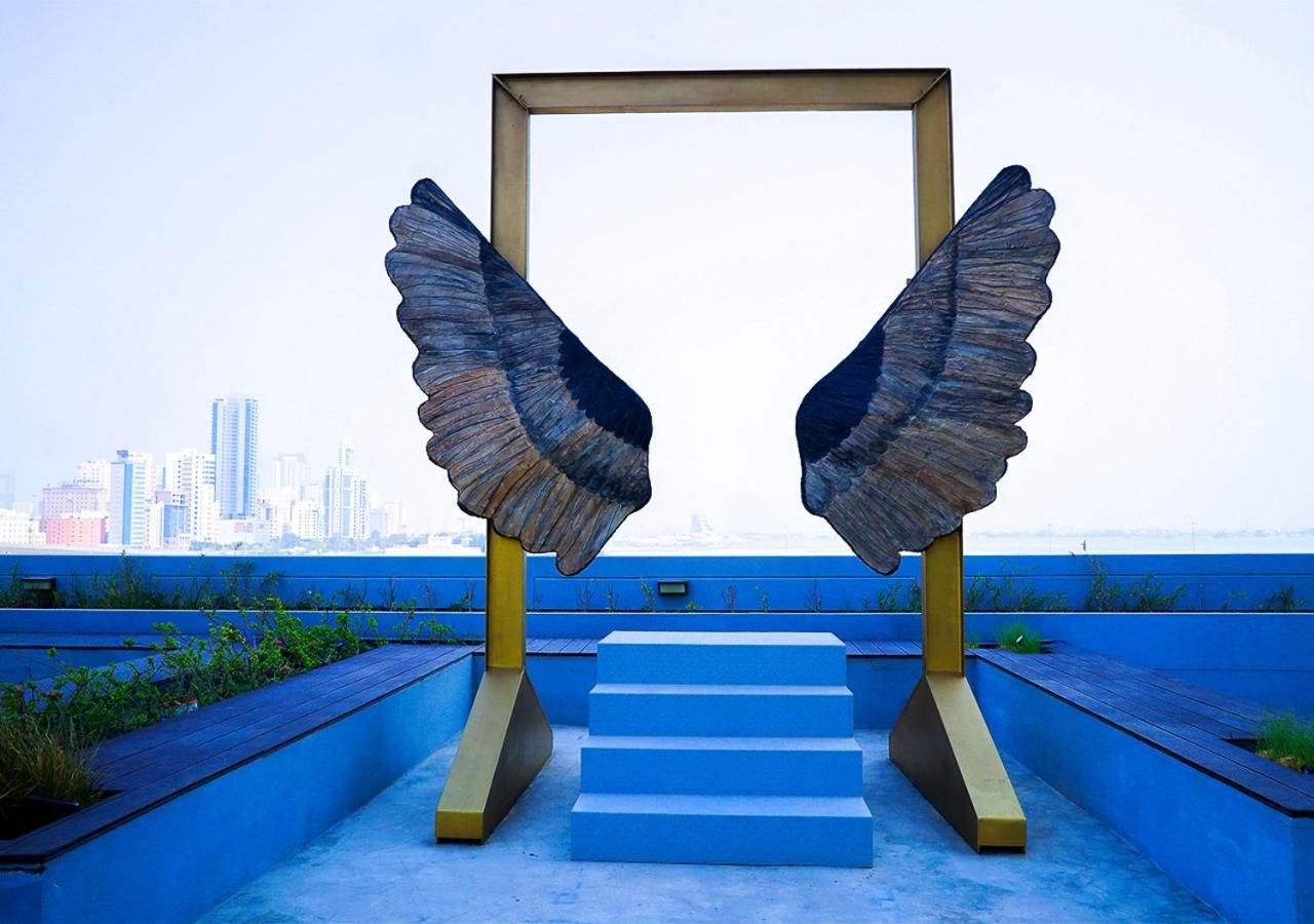 a framed mirror with wings on top of a building at Farhan Tower in Juffair
