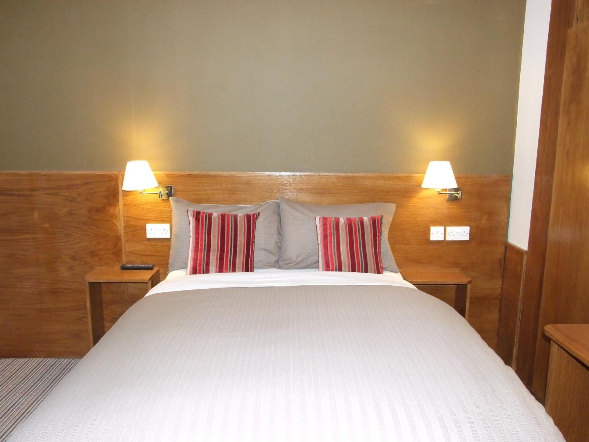 a bedroom with a large bed with two red and white pillows at Leith House in Edinburgh