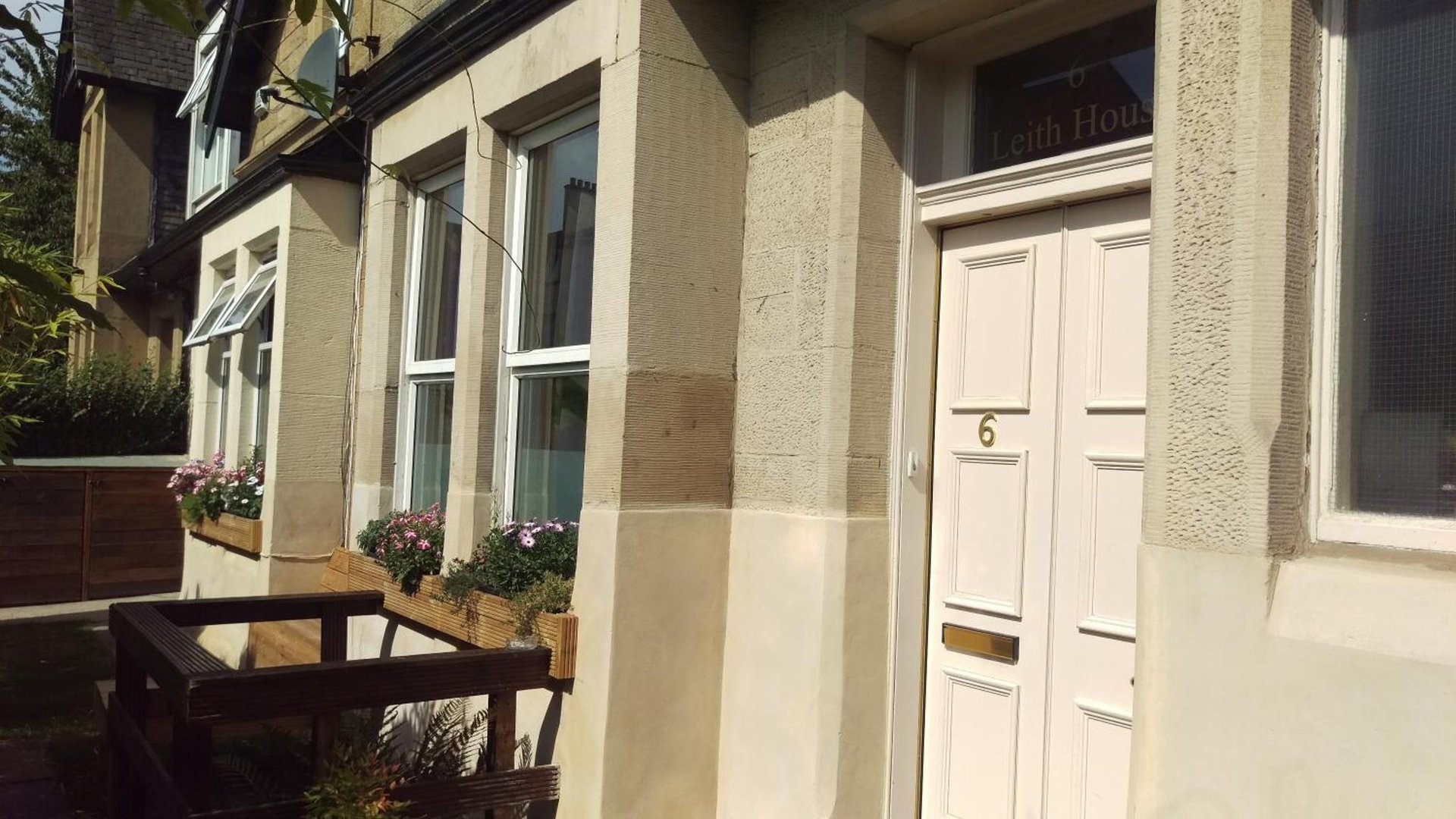 a building with a white door and a bench at Leith House in Edinburgh