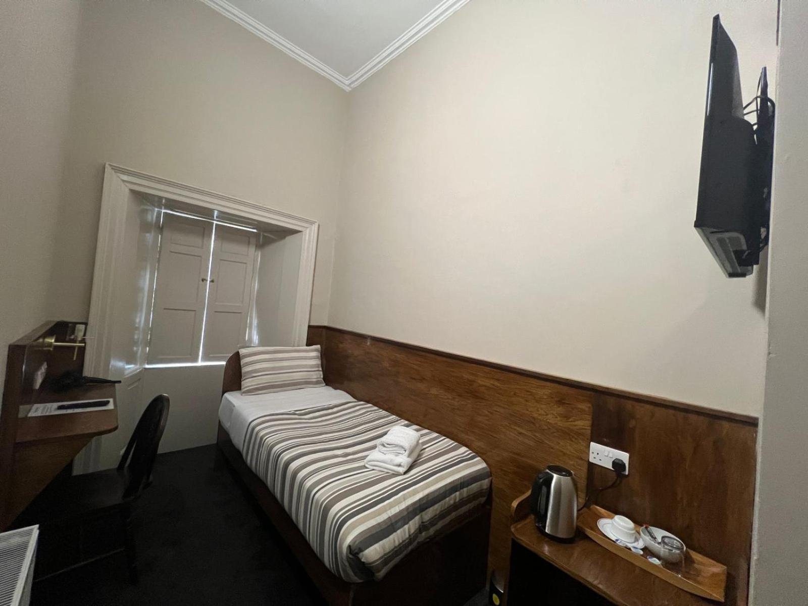 a small room with a bed and a television at Burntisland House in Burntisland