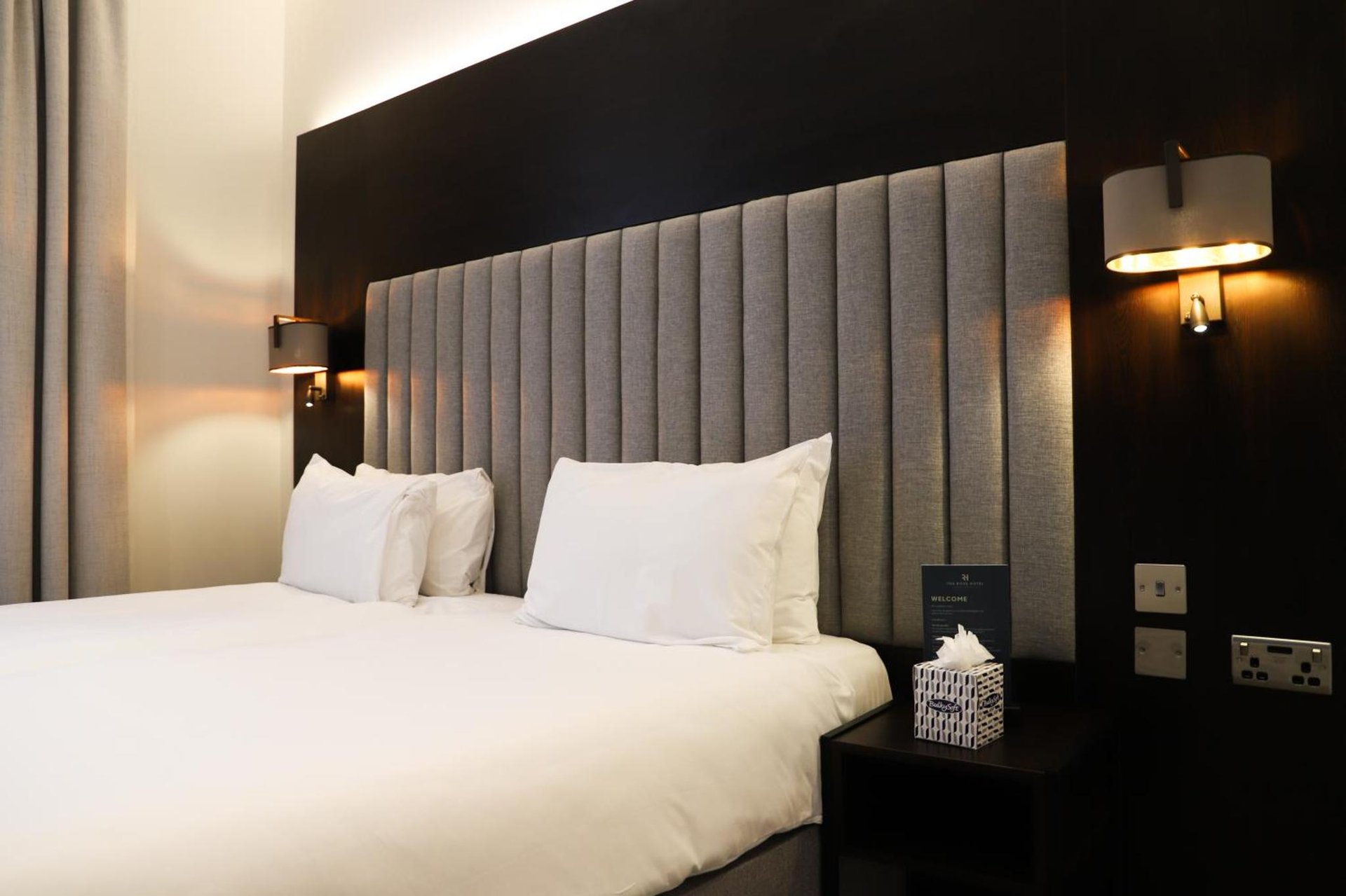 a bedroom with a large bed with white pillows at Rove Hotel London Paddington in London