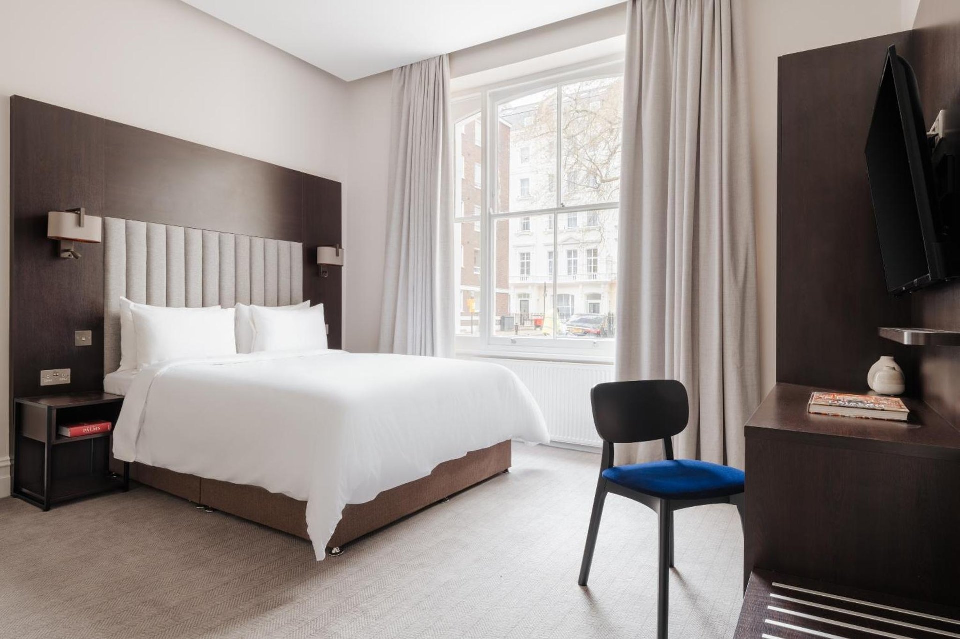 a bedroom with a large white bed and a window at Rove Hotel London Paddington in London