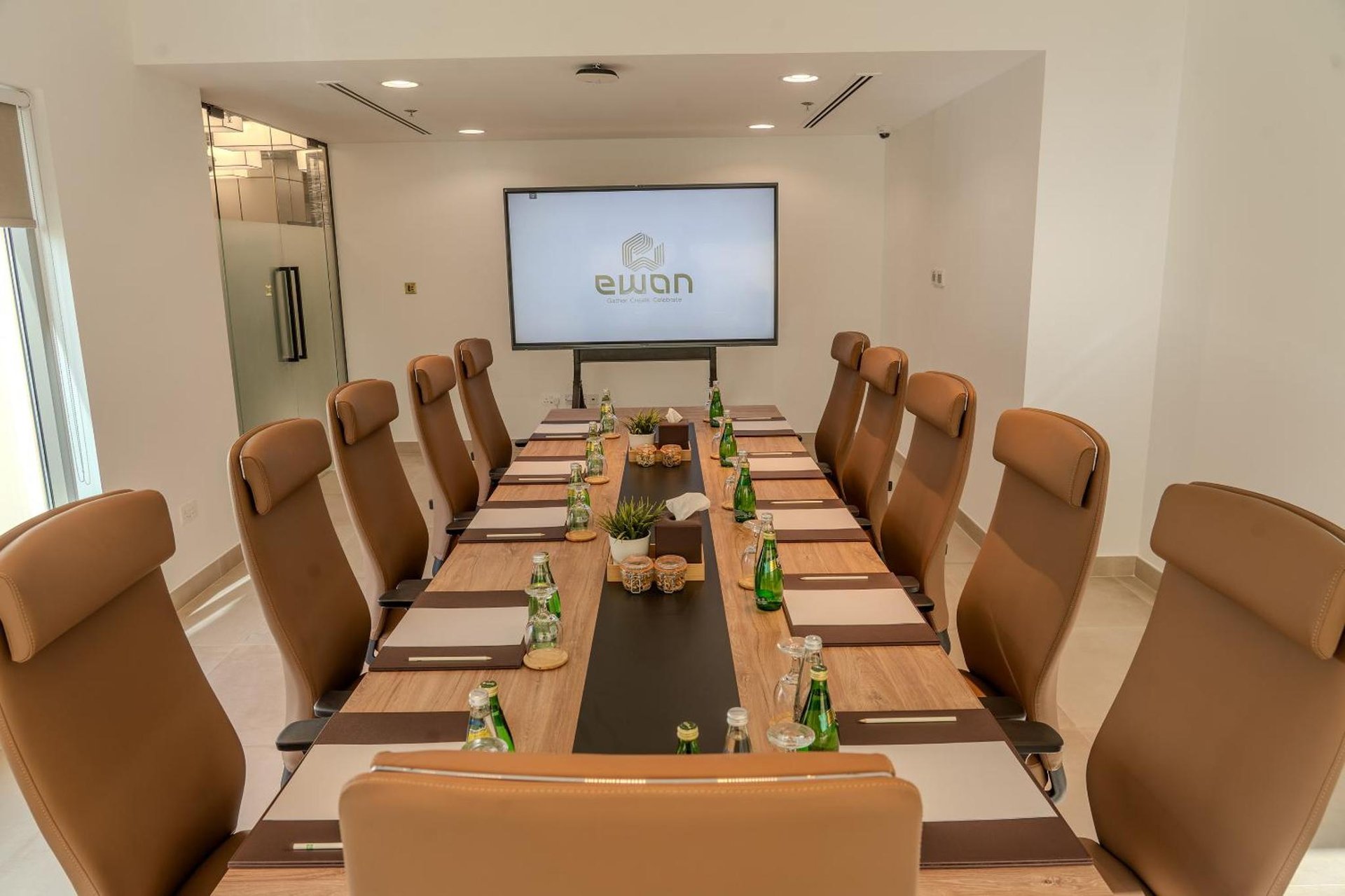 a boardroom with a long table and chairs and a screen at Ibis Styles Dubai Jumeira in Dubai
