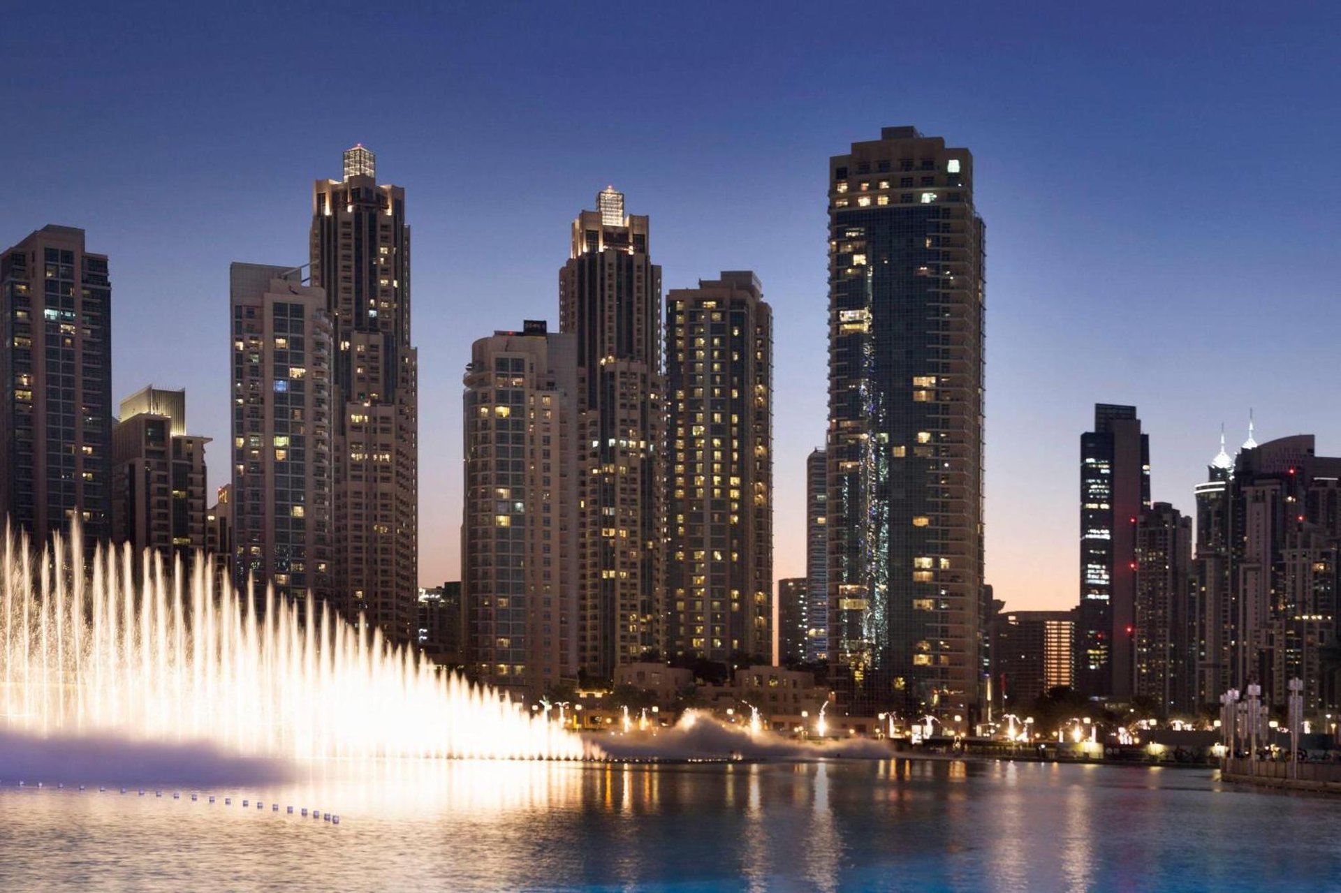 a water fountain in front of a city at night at Ramada by Wyndham Downtown Dubai in Dubai