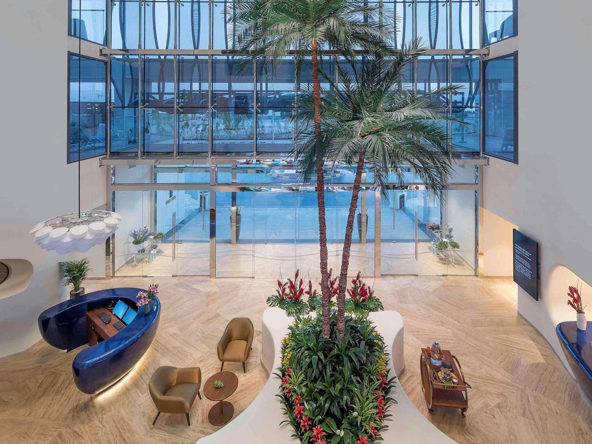 a large indoor pool with a palm tree in a room at The Retreat Palm Dubai MGallery by Sofitel in Dubai