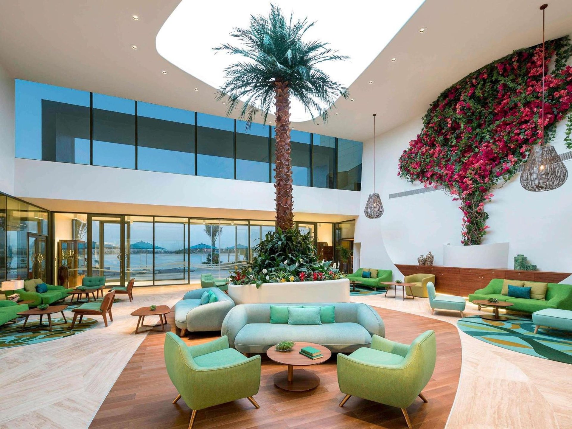 a lobby with a blue couch and palm trees at The Retreat Palm Dubai MGallery by Sofitel in Dubai