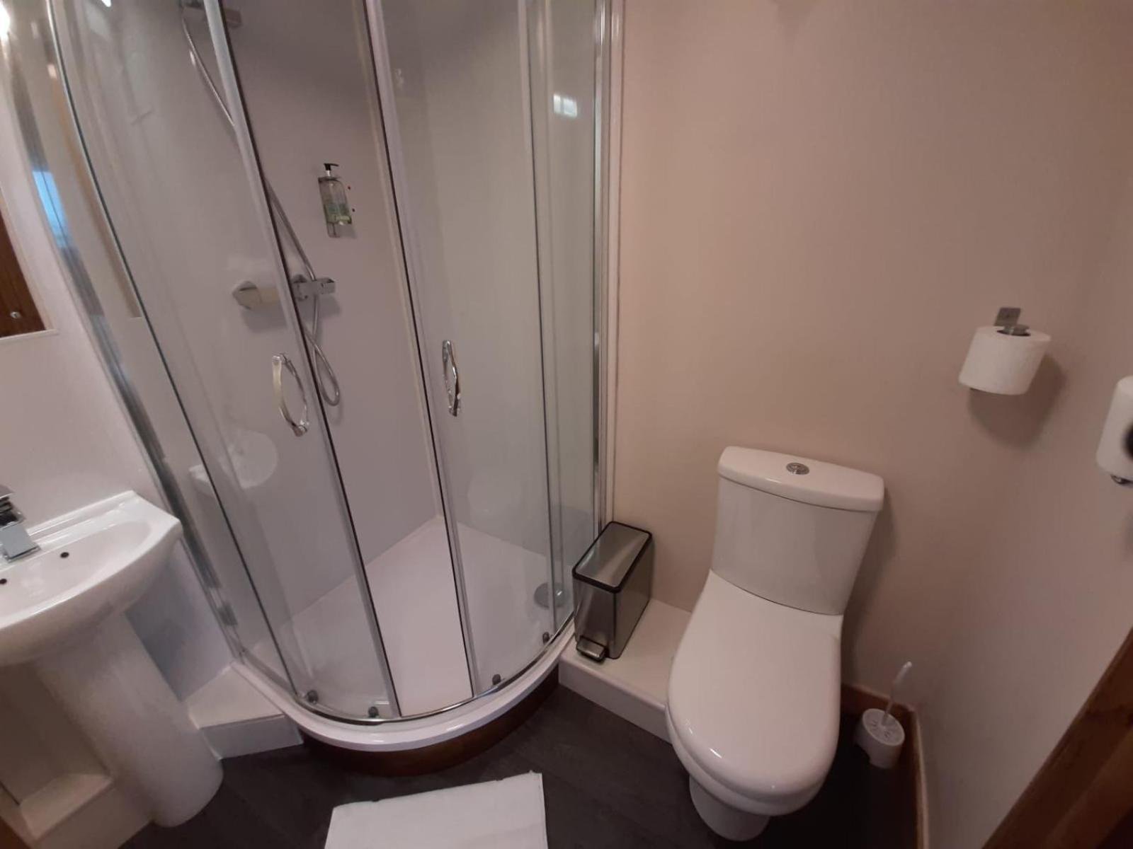 a bathroom with a shower and a toilet and a sink at Adelphi Hotel in Edinburgh