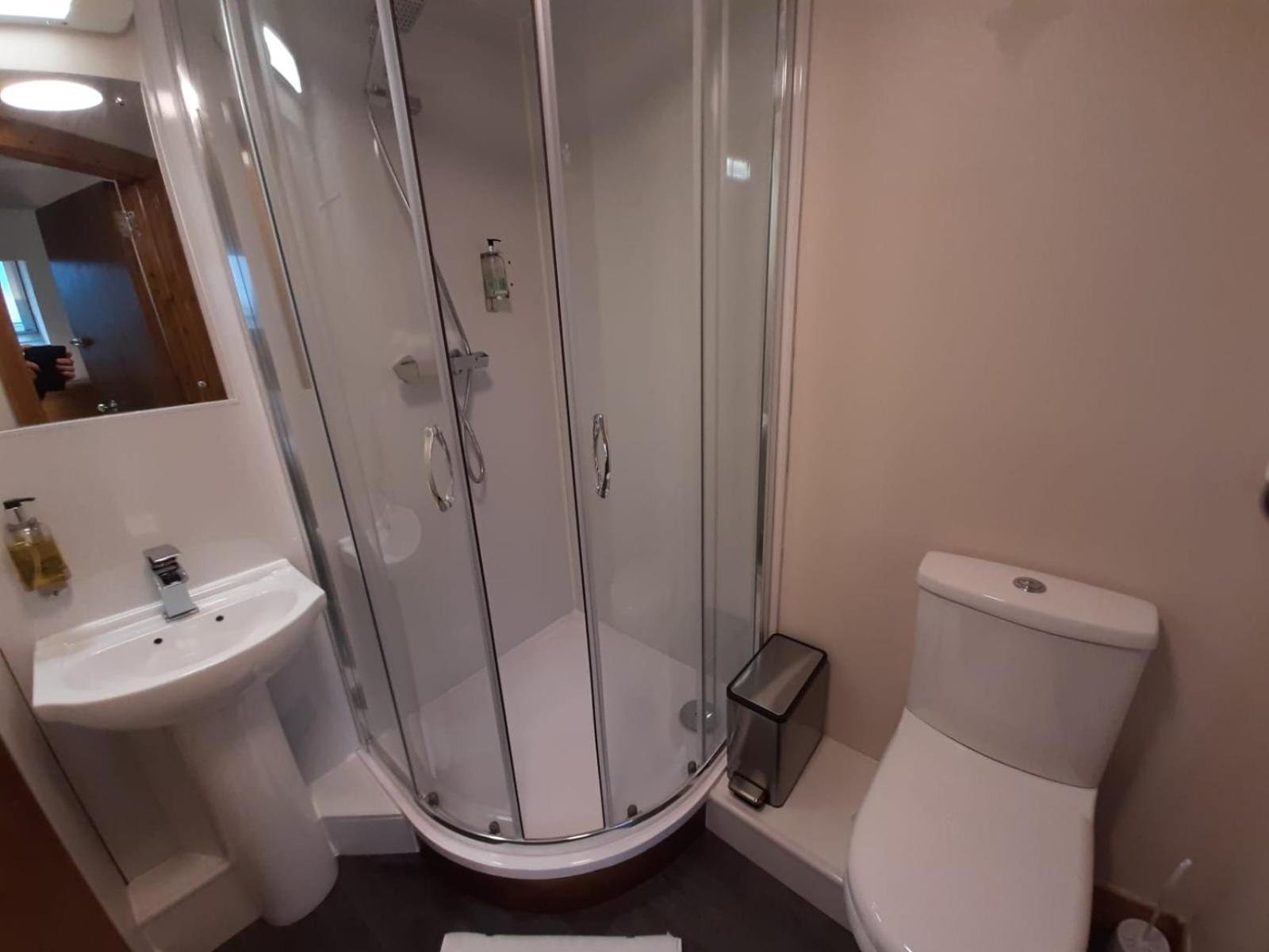 a bathroom with a shower and a toilet and a sink at Adelphi Hotel in Edinburgh